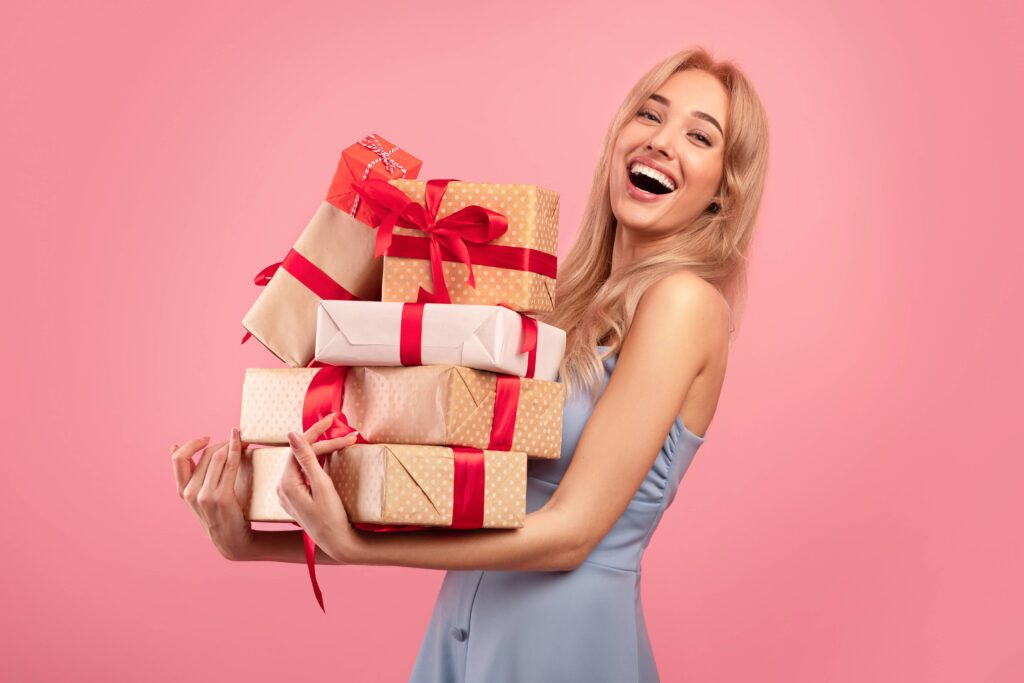 Woman carrying presents with pink background