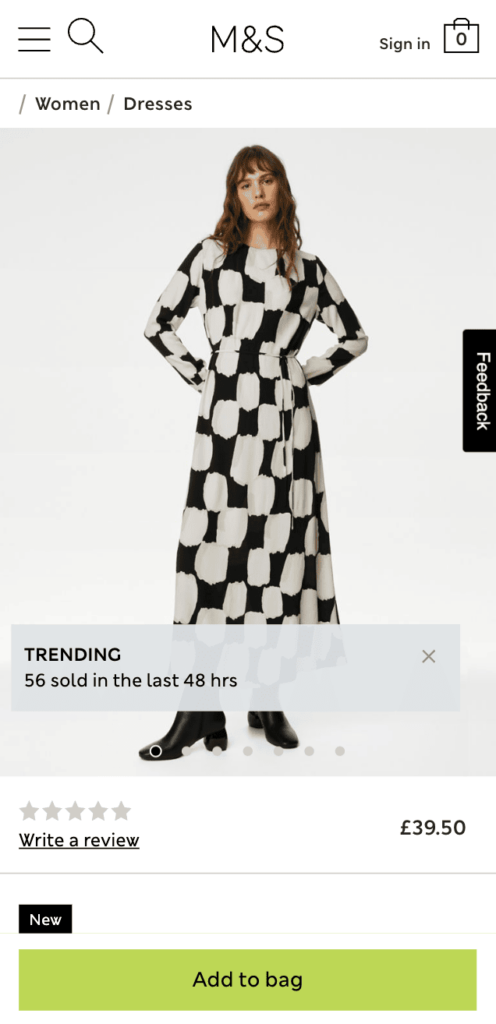 M&S website in mobile view showing a woman in black and white dress with a social proof message "Trending! 56 sold in the last 48 hours"